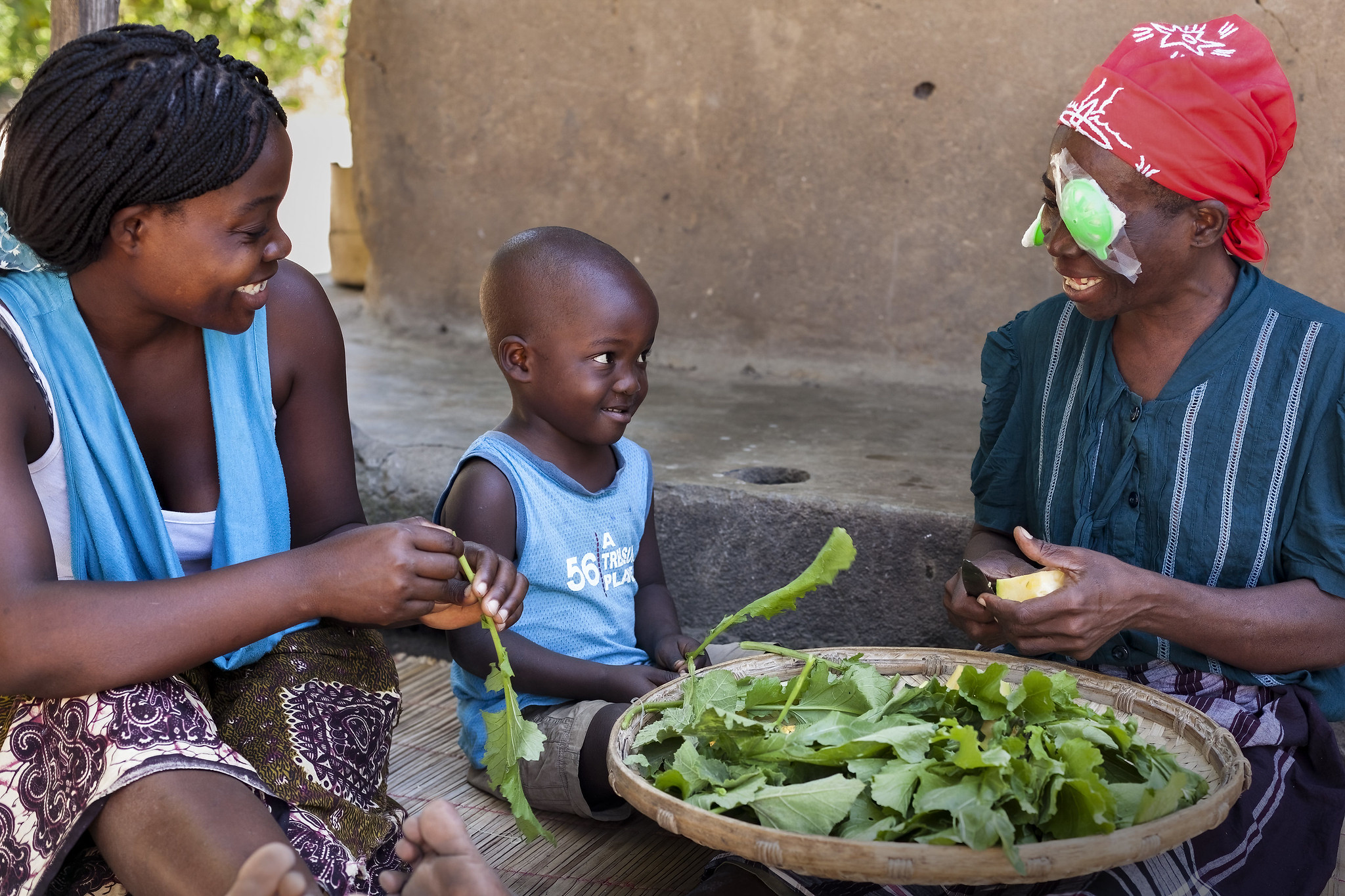 a woman with a cataract bandage helps prepare food with family 