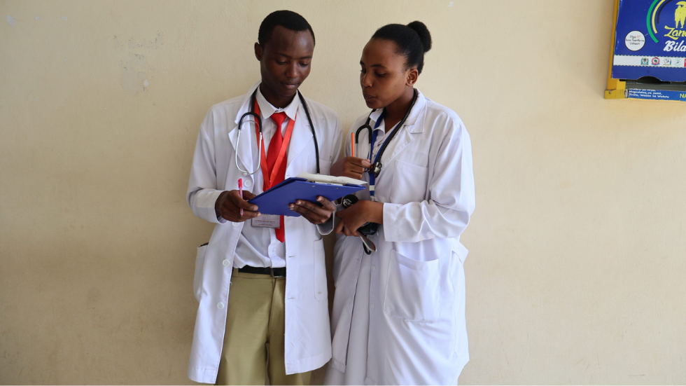 two trainee doctors compare notes outside a clinic