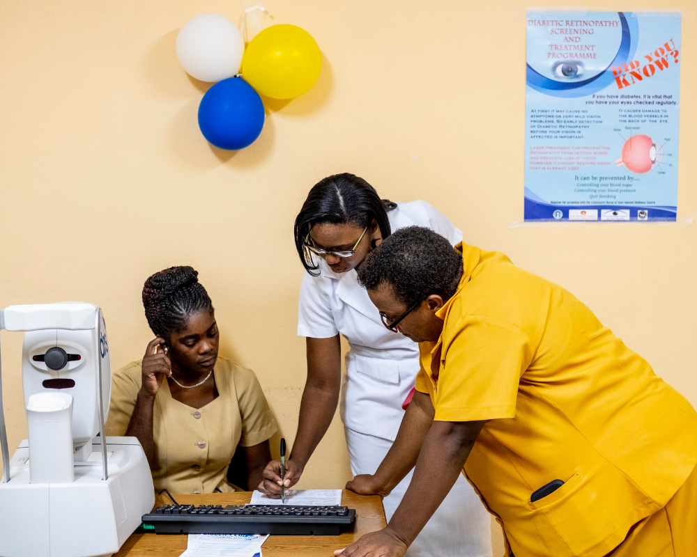 In St. Lucia, three health workers gather round a table to look at a form