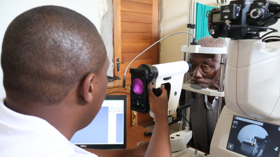 a doctor screens a patient's retina using a smartphone-assisted device 