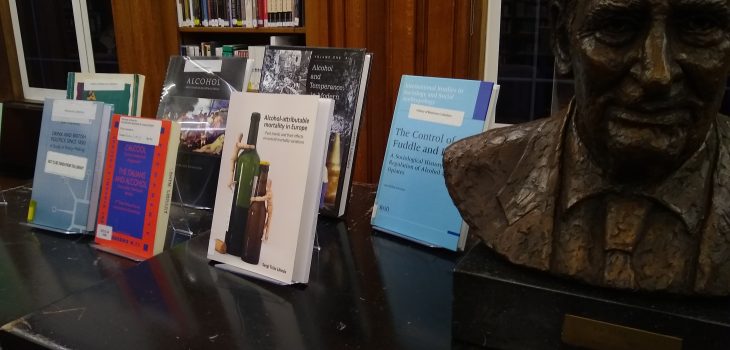 Photograph of Dry January book display consisting of eight books, with bust of Sir Richard Doll on the right.