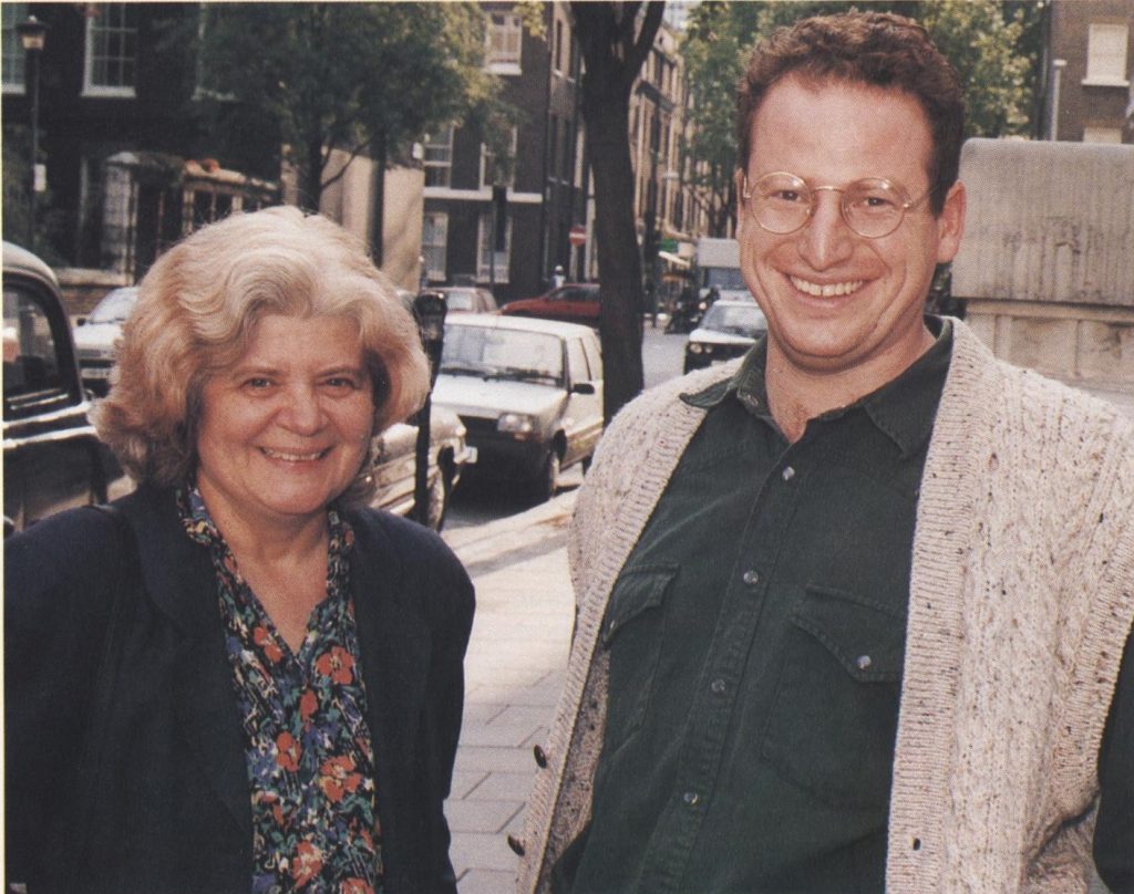 Colour photograph of Jenny Roberts and a male colleague outside the LSHTM Keppel Street building. 