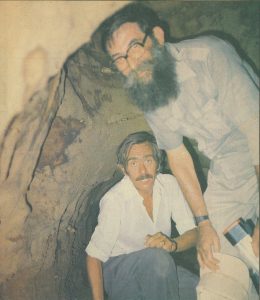Colour photo newspaper cutting of Donald Minter and colleague, taken in a  Cypriot cave, 1991