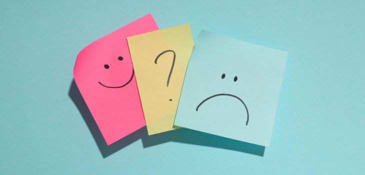 Photo showing three post-it notes with a happy face, a question mark, and a sad face.
