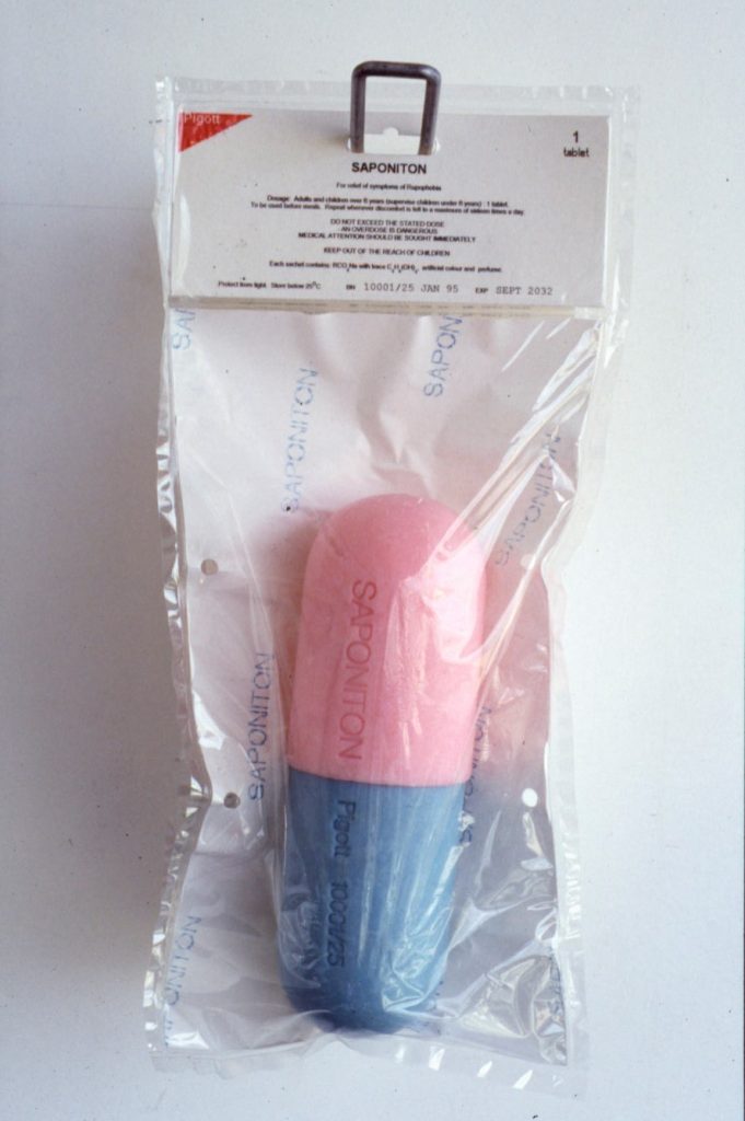 Pink and blue soap bar in the shape of a drug capsule in plastic packaging