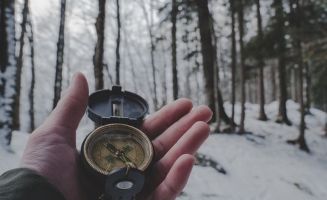 Image of hand holding a compass.