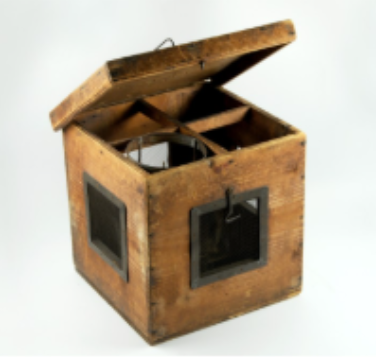 Image of old square wooden box, the lid is slightly ajar making visible 4 sections. 