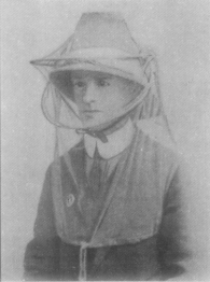 Greyscale image of a woman wearing a mosquito hood